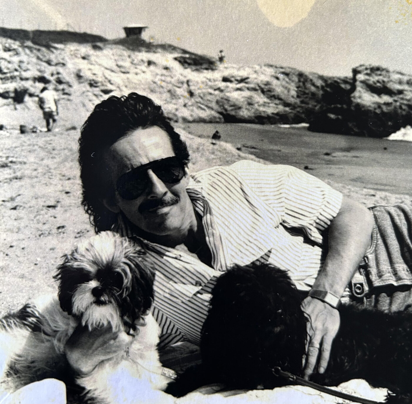 Joseph on a beach with his dogs Snap and Bacchus