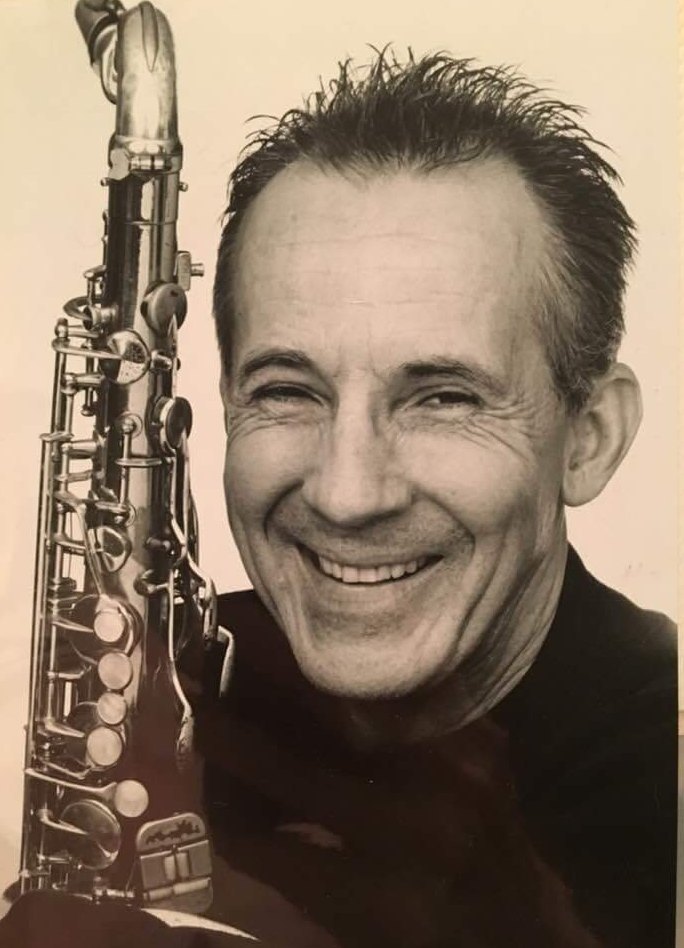 Joseph smiling, holding his saxophone