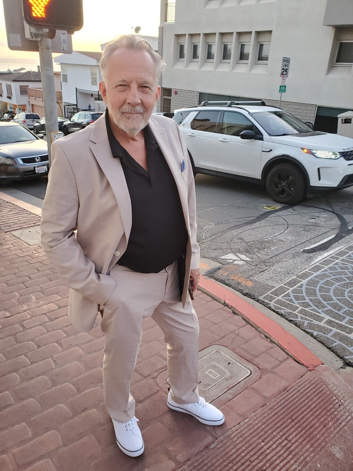 Joseph in a cream suit on a street corner